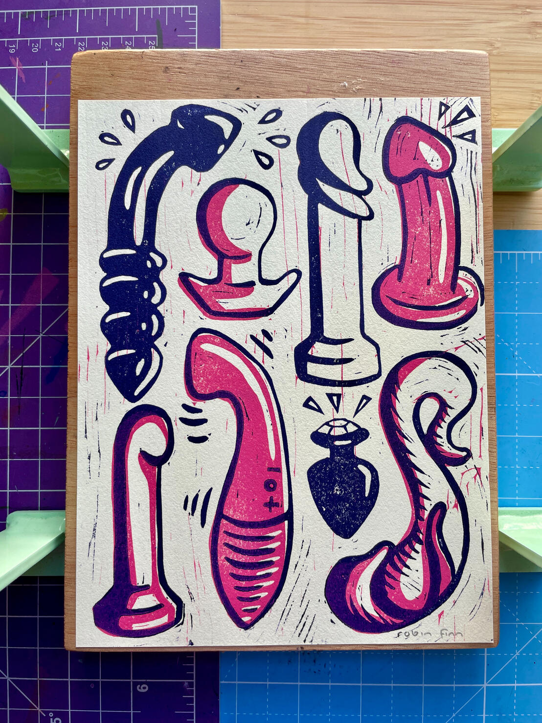 Linocut print of a variety of sex toys in pink and dark purple: glass and silicone dildos, a g spot vibrator, and butt plugs.